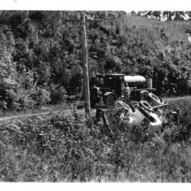 David Nicol looking at an overturned lorry where the road side gave way, 1938 