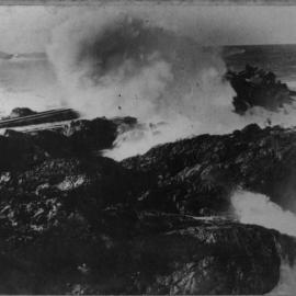 A stormy day at Jetty Beach with waves crashing over the tramline, early 1900s