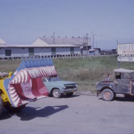 Decorated backhoe in street parade, Coffs Jetty, 1964