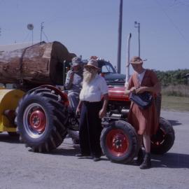 Men in costume with tractor and Limblo machine in street parade, Coffs Jetty, 1964