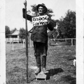 Tom Richards holding 7 foot long carpet snake, Red Rock, 1930