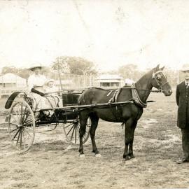 Captain Colvin standing by two women and child with a horsedrawn buggy, c. 1900