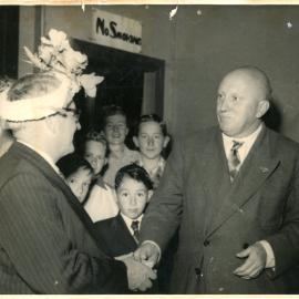 George England tries not to laugh at Jack Gerard's hat, c. 1950 - 1951