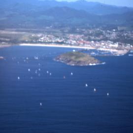 Sails of the Hobie catamarans beyond the Harbour, 1977