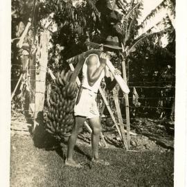Ray Kratz shoulders a bunch of bananas, 1940