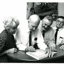 Neil Yeates signs a copy of his Coffs Harbour history, 1990