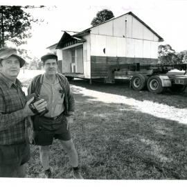 Two men moving a house