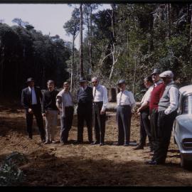 Group of men on dirt road, c. 1963