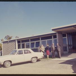 Group of people in front of building, c. 1966