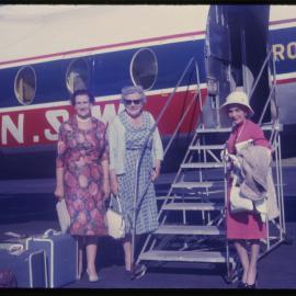 Three women about to board airplane, c. 1962