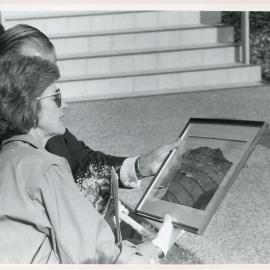 Lady Rowland admires a painting of the marina, 18 April 1985