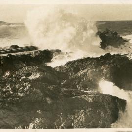 Waves break over the breakwall tramway, c.1933