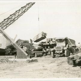 A crane transfers timber, 1936