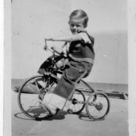 Jeffrey Hobman rides his tricycle on South Solitary Island, 1951