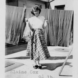 Elaine Cox outside the laundry with fish, 1952