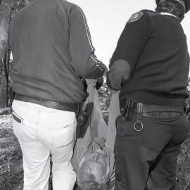 Graham Ashton is carried to the paddy wagon, late 1991