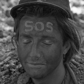 A protestor is buried up to his neck in the sand, late 1991