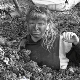 A protestor is buried up to her neck in the sand, late 1991