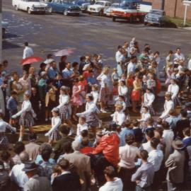 Viewing a parade along High Street after a storm, c.1960