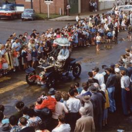 Viewing a parade along High Street after a storm, c.1960