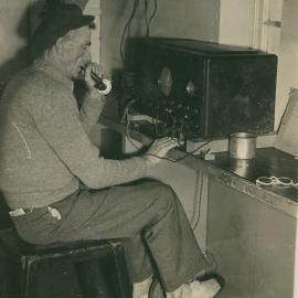 Lightkeeper Jim Duncan using a pedal radio at South Solitary Island lighthouse, 1946