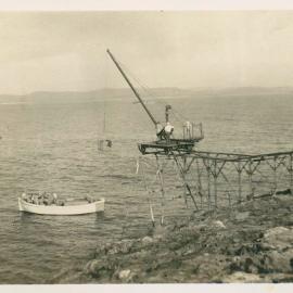 South Solitary Island jetty with crane and launch in a calm sea, 1946