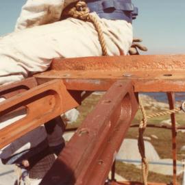 Workmen balance on top of the South Solitary Island Lighthouse