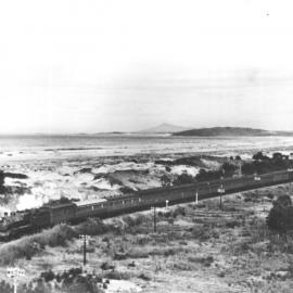 The railway line cuts through the sand dunes