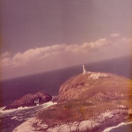 Helicopter view of South Solitary Island Lighthouse and Arch Rock, mid 1970s
