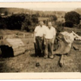 Photograph of men with fallen logs